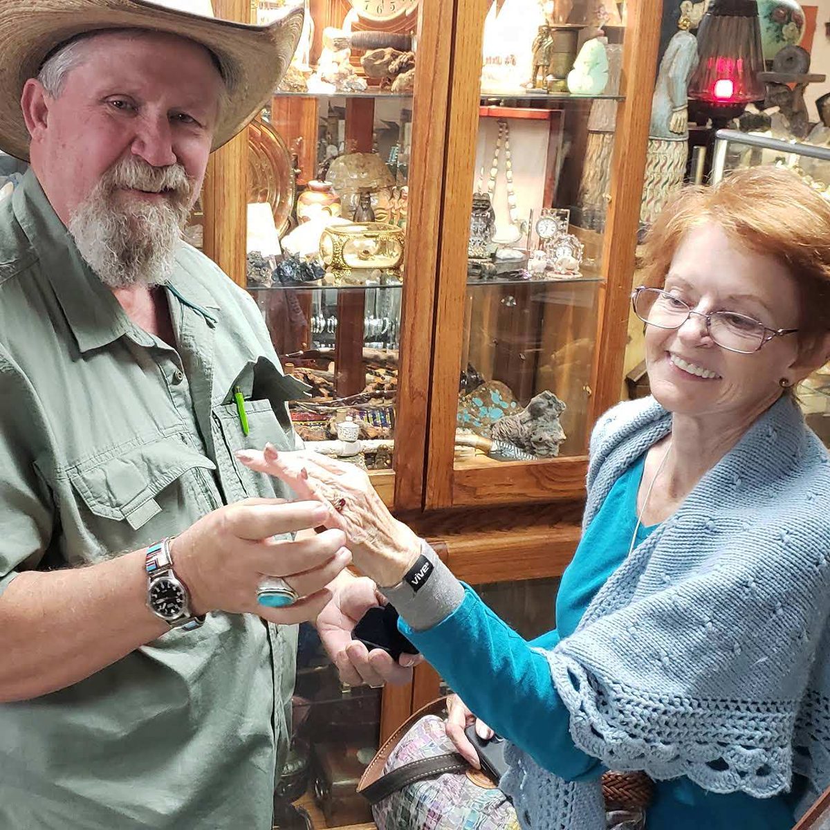 Rick, the owner, showing a ring to a customer at the counter